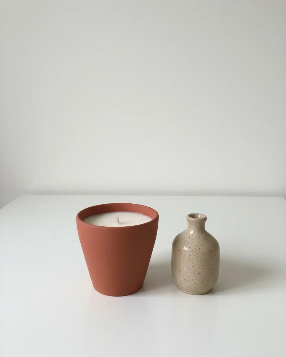 Avant : photo smartphone d'une bougie en terre cuite et d'un vase sur une table blanche