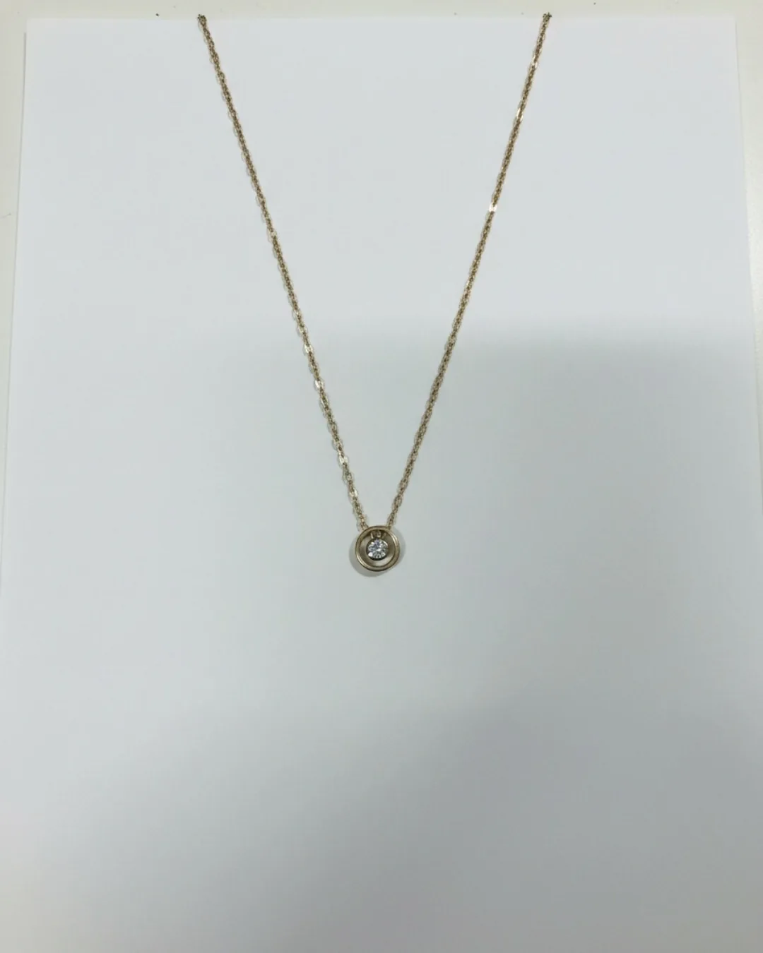 Avant : photo smartphone d'un collier posé sur une feuille blanche